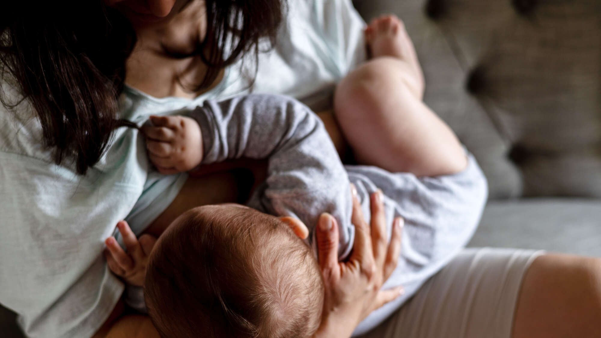 mother woman breastfeeding baby boy sitting on sofa.child infant